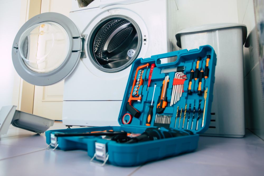 A washing machine and tools in a laundry room, illustrating an appliance repair service located in Spokane, WA.