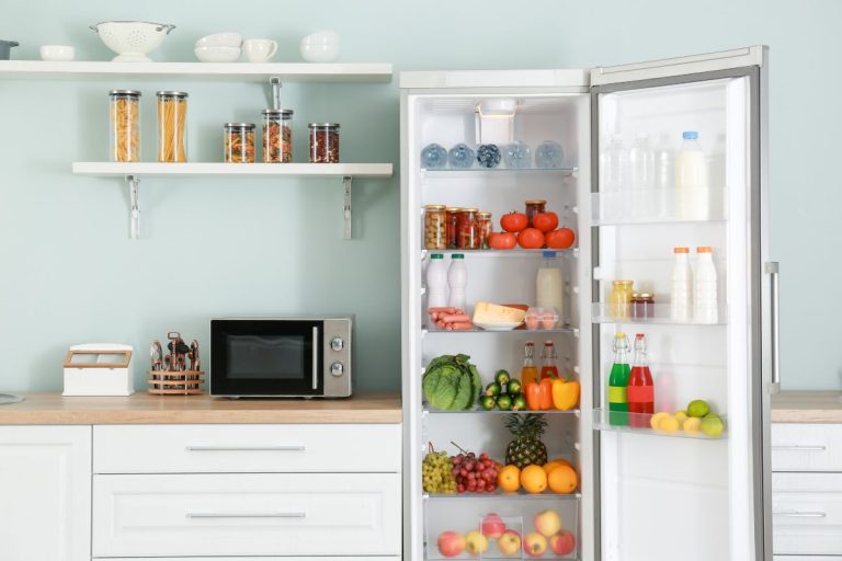 An open refrigerator filled with various food items, highlighting the need for appliance repair.