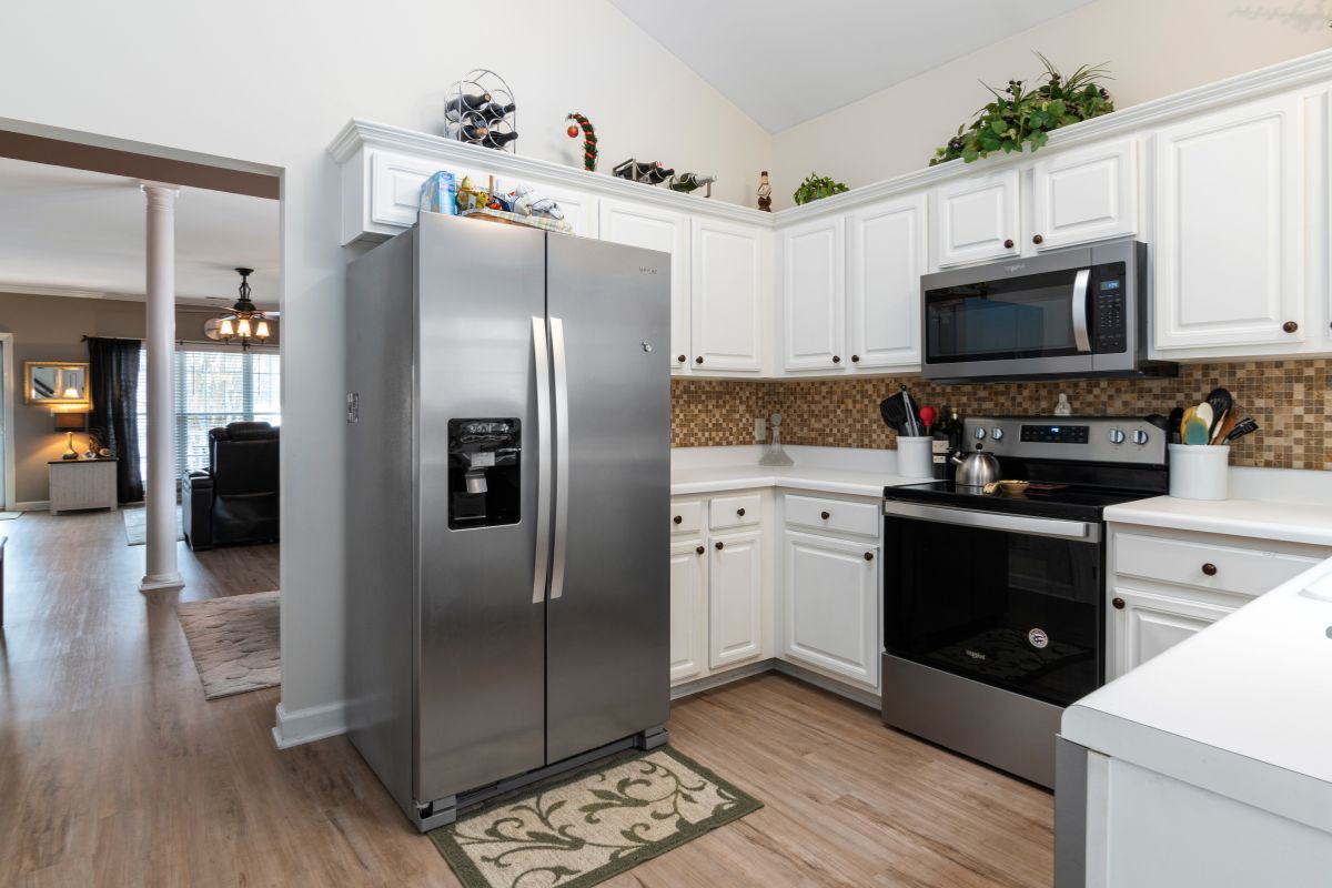 A modern kitchen featuring stainless steel appliances and warm wood floors, ideal for appliance repair and maintenance tasks.